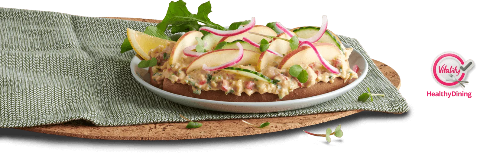 A grilled sandwich filled with creamy chickpea mayo, garnished with greens