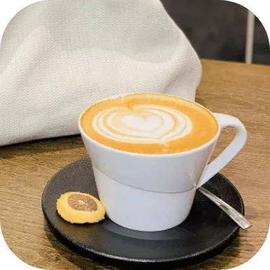 Cappuccino in white cup with biscuit