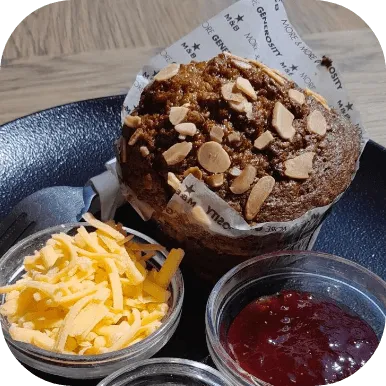 Giant muffin with a bowl of cheese and jam