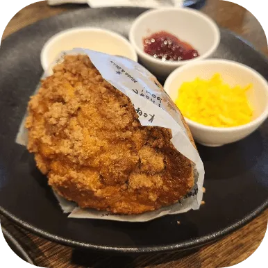 Giant muffin with a bowl of cheese and jam