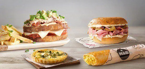 A vibrant brunch spread with sandwiches, quiche and bagel