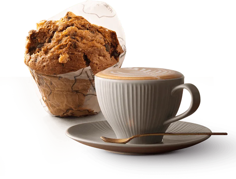 A creamy cappuccino in a white cup with a giant muffin
