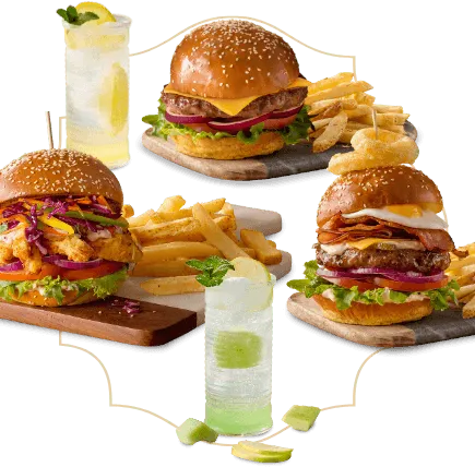 Three burger meals with chips on serving plates with two cool drinks Three burger meals with chips on serving plates with two cool drinks