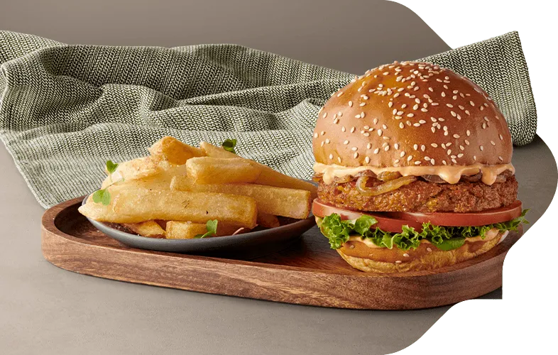 Plant-based burger and chips meal on a wooden serving board Plant-based burger and chips meal on a wooden serving board
