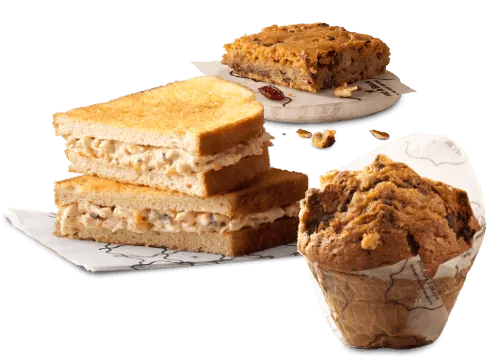 A toasted sandwich, a sweet treat and huge muffin on a white background