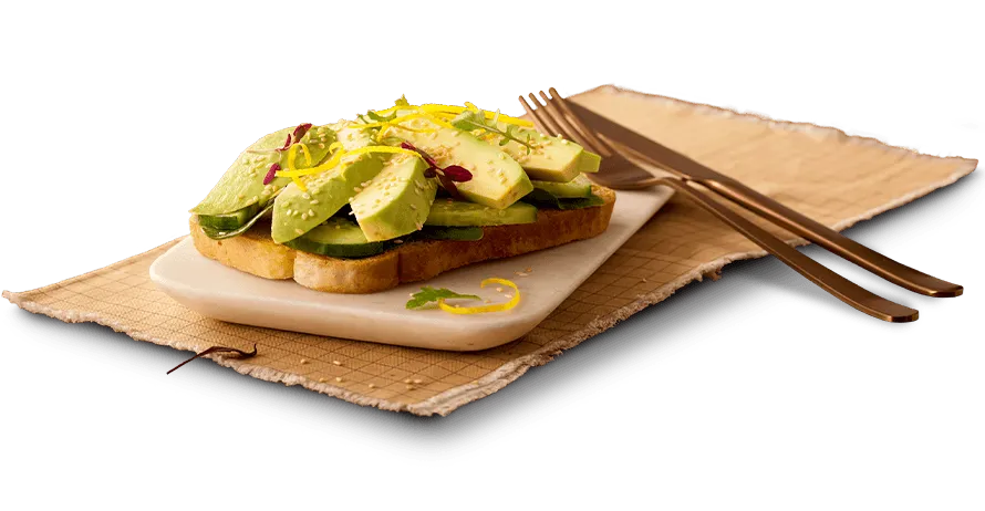 Avo on Toast on a plate with utensils alongside Avo on Toast on a plate with utensils alongside