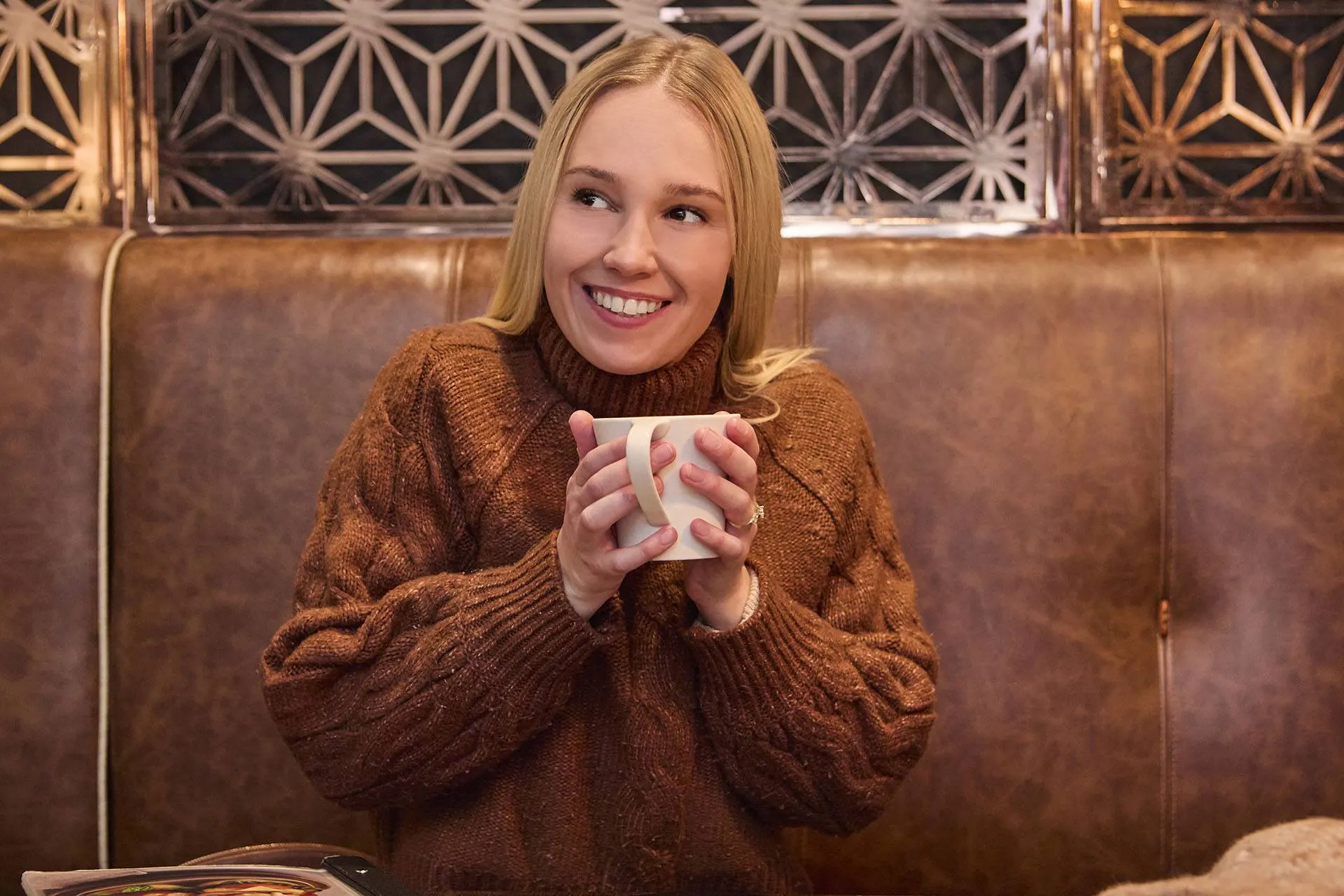A lady sitting in and enjoying a warm coffee A lady sitting in and enjoying a warm coffee