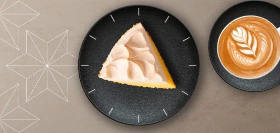 Cake on a plate next to a coffee