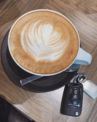 Coffee cup with car keys on table