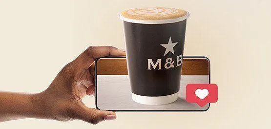 M&B takeaway coffee and person holding phone