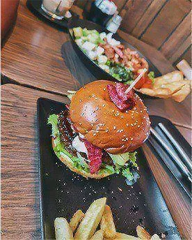 M&B burger with chips on a black plate