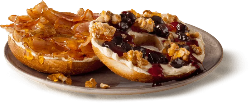 A toasted bagel topped with cream cheese and blueberries A toasted bagel topped with cream cheese and blueberries