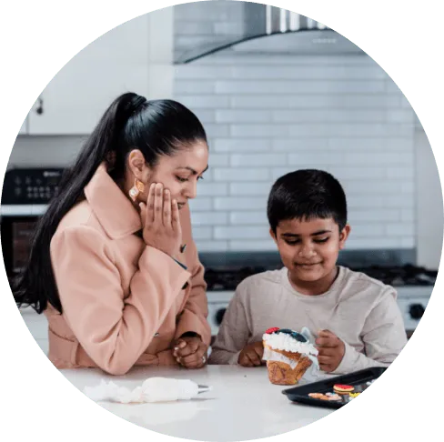 Armaan and his mom looking at a cupcake