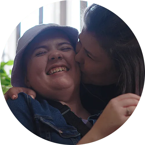 Mom kissing her daughter on the cheek