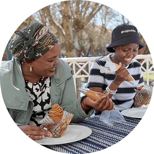 Mpho eating cupcakes with mom outside