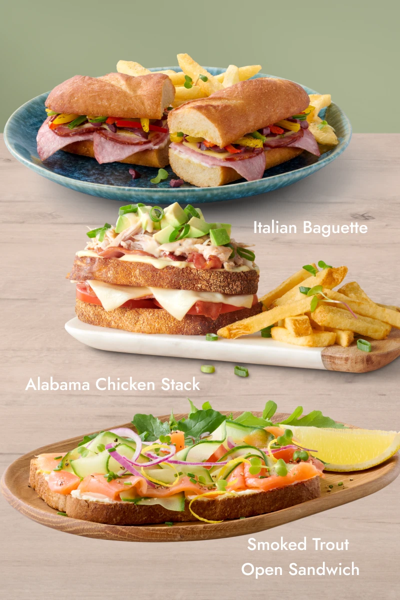 Three gourmet sandwiches — Italian Baguette, Alabama Chicken Stack, and Croque Madame — each served with fries on separate plates.