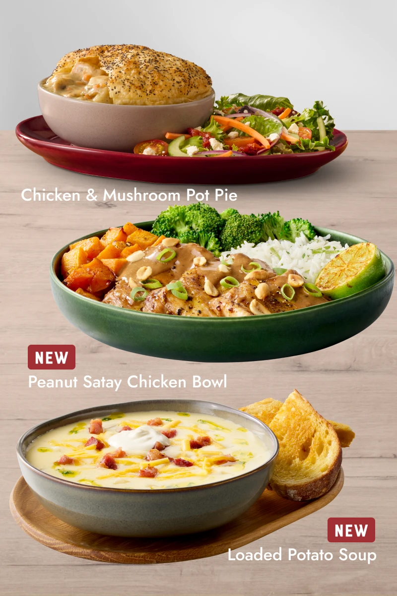 Three plated meals on a wooden table: Chicken Mushroom Pot Pie with side salad, Rump steak with chicken wings, onion rings, fries, and dipping sauce, and a Mediterranean Veg Bowl with grains, vegetables, and herbs.