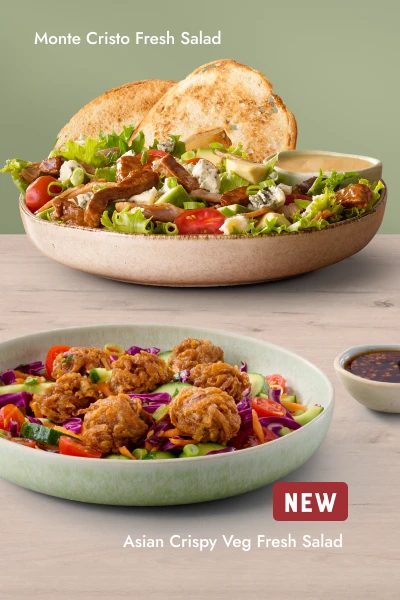 Two fresh salads — Monte Cristo Fresh Salad and new Asian Crispy Veg Fresh Salad — served in bowls with a side of dressing.