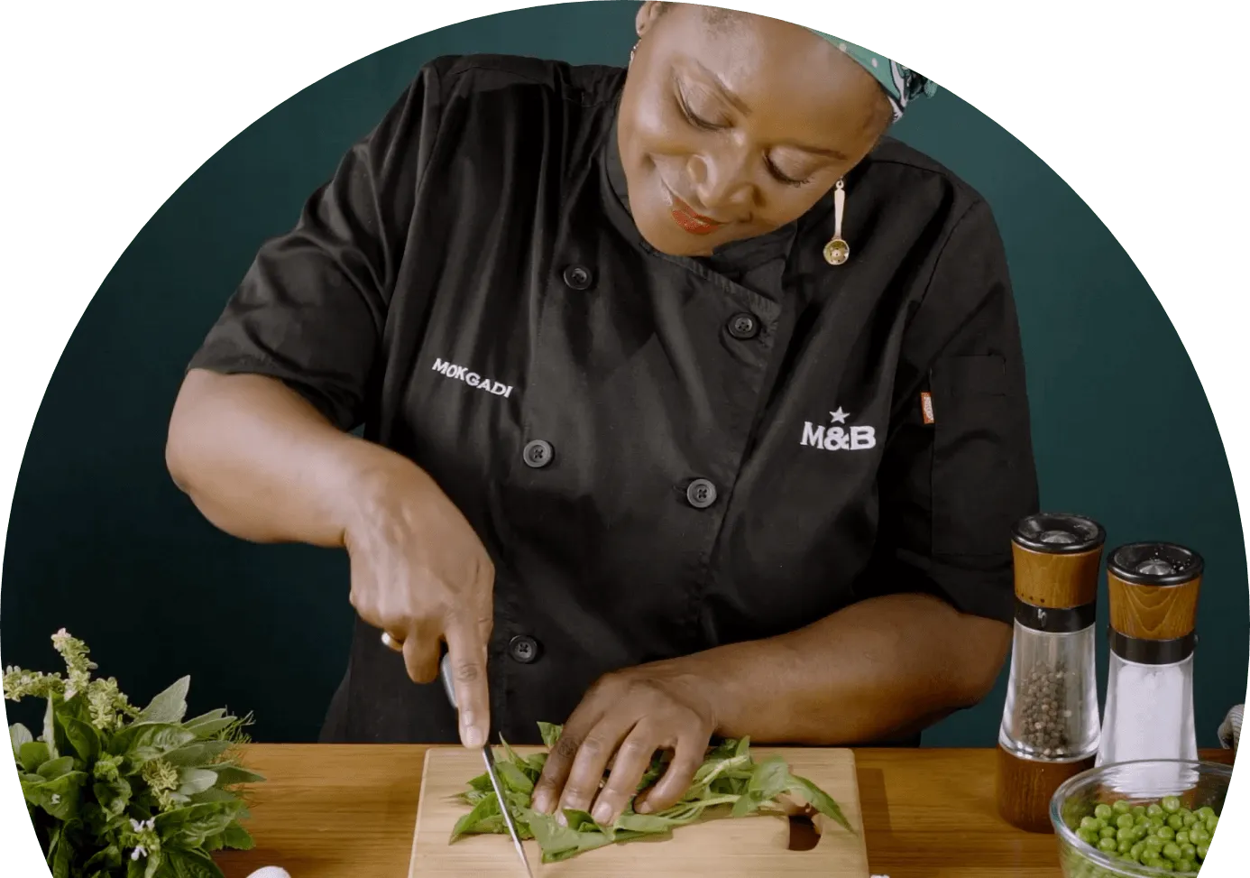 Chef Mokgadi slicing leaves on a wooden board
